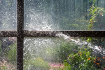 Ein Wasserstrahl trifft auf eine Glasscheibe.