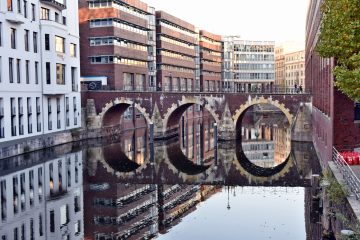 Brückenbögen der Ellerntorsbrücke spiegeln sich im Fleet.