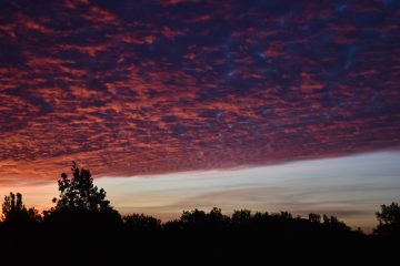 Bei einem Sonnenaufgang ziehen die Wolken vorbei.